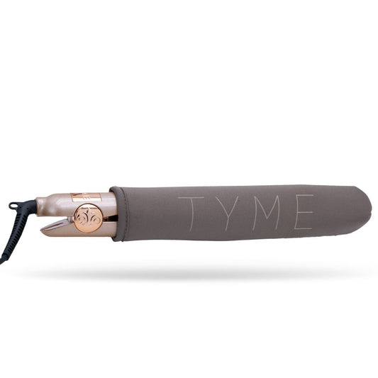 The TYME Iron Pro inside of it's dark taupe fabric Heat Sleeve with TYME name on the side, used for safety, storage and travel.