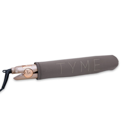 The TYME Iron Pro inside of it's dark taupe fabric Heat Sleeve that's included with purchase for safety, storage and travel.